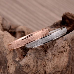 Anelli minimalisti in acciaio inossidabile opaco, oro rosa e argento su base legno