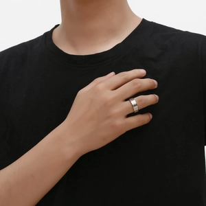 Detail of silver dragon pattern titanium steel ring showing geometric texture on male finger