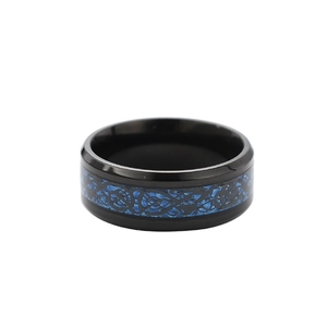 Detail of black polished stainless steel ring with blue carbon fiber and dragon pattern inlay