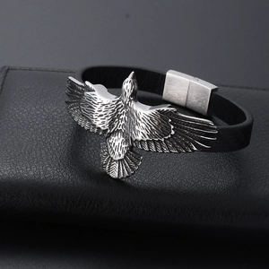 Vue macro de l'aigle en argent sur un bracelet en cuir tressé noir avec fermoir brossé