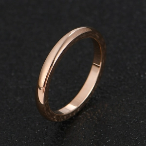 Minimalist 2mm rose gold stainless steel ring with a polished mirror finish on dark surface