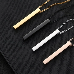 Macro detail of minimalist rectangular bar pendants in gold, silver, black, and rose gold