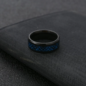 Close-up of men's black stainless steel ring with blue Celtic dragon pattern inlay