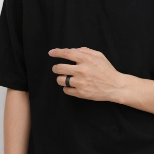 Détail d'une bague en acier tungstène noir mat de 8mm au doigt avec une finition brossée