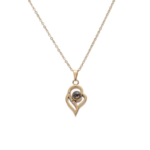 Collier projection cœur doré en acier inoxydable avec cristaux sur fond blanc épuré