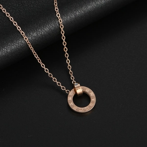 Rose gold Roman numeral ring necklace with a small zircon on black textured background