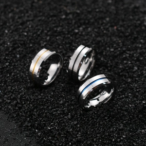 Macro shot of 8mm tungsten rings with gold silver and blue grooved inlay details