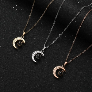 Three moon and star projection necklaces in gold, silver and rose gold on black background