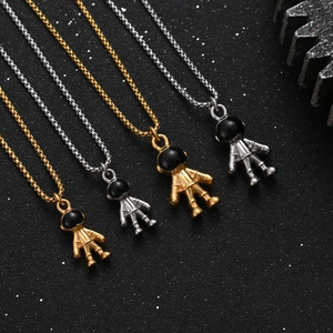 Detail showing four astronaut pendant necklaces in gold and silver on a space-themed background