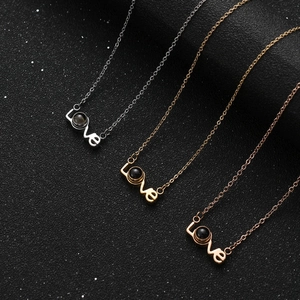 Three I Love You Projection necklaces in gold, silver, and rose gold on black background