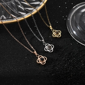 Three clover projection necklaces in rose gold, silver, and gold on a black background