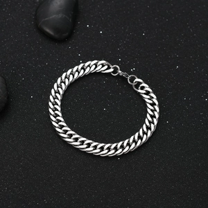 Bracelet gourmette pour homme en acier inoxydable argenté poli sur un fond noir texturé