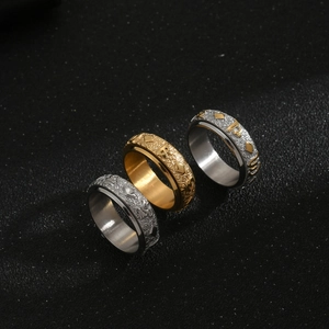 Macro shot of three rotatable rings with vintage Buddhist mantra relief engravings