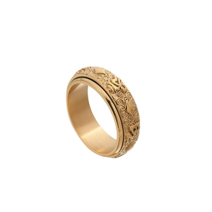 Detailed macro of golden rotatable titanium ring with vintage relief religious patterns