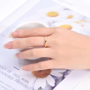 Polished 2mm gold tungsten ring shown on finger for a minimalist fashion look