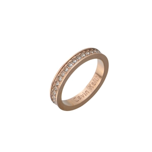Détail macro d'une bague en or rose avec cristaux pavés et gravure de marque interne