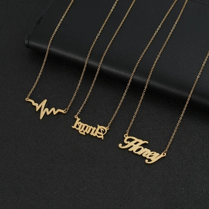 Détail de trois colliers dorés avec pendentifs Legend, Honey et battements de cœur sur cuir noir