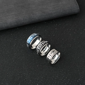 Detailed shot of three Viking rune rotating rings in blue, black, and silver stainless steel