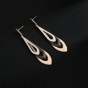 Rose gold and black frosted teardrop earrings with Love engraving on textured background