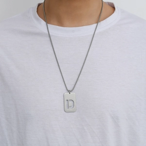 Detail of a men's brushed titanium steel military tag necklace with hollow letter D