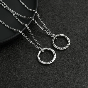 Macro view of Mobius ring pendant with 'ROAD HERE' engraving on retro silver titanium steel
