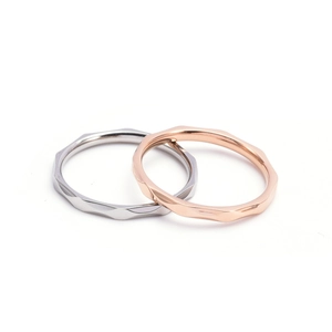 Détail macro de bagues géométriques minimalistes de 2 mm en finitions argent et or rose