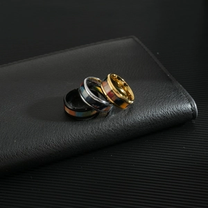 Three-piece stainless steel ring set with rainbow wood inlay on black leather