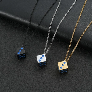 Three dice pendants in black, silver, and gold steel with blue enamel dots on leather