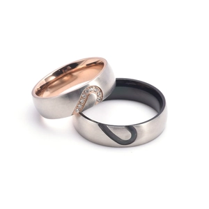 Vue macro de bagues de couple cœur assorties avec finition acier brossé et pierres