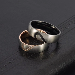 Bagues de couple en acier brossé avec intérieur or rose et petits cristaux de zircone