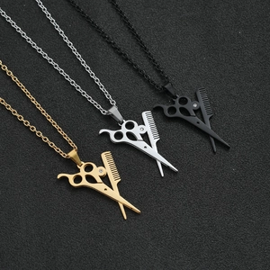 Macro detail of barber scissors and comb pendants in gold, silver, and black finish