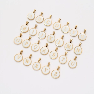 Detailed set of 26 gold alphabet pendants with white enamel on a clean white background