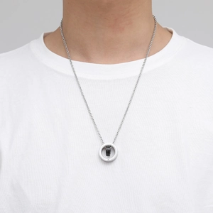 Collier double anneau en acier titane pour homme avec anneau noir porté sur un t-shirt blanc