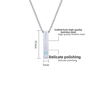 Detailed view of silver bar pendant with Forever Love engraving and blue gemstone