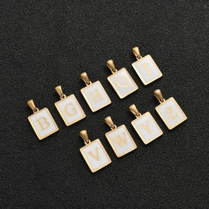 Gold stainless steel rectangle letter pendant necklaces set on black leather surface