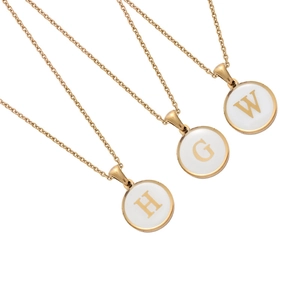 Detail of round gold necklaces with white enamel and H, G, W letters on cross chains