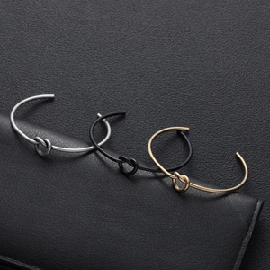 Three-piece minimalist knot cuff bracelets in silver, gold, and black stainless steel