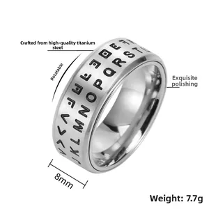Macro view of 8mm rotating stainless steel ring with engraved letters on a polished band