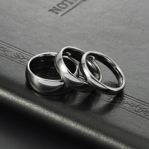 Three pieces of polished gunmetal tungsten steel rings in various widths on black leather