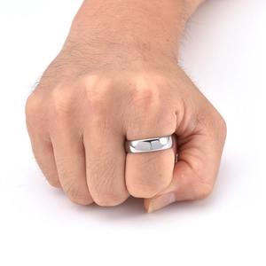 Close-up of a high-polished silver tungsten steel band ring on a hand with a white background