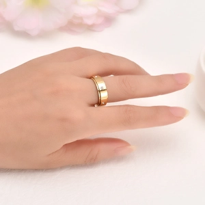 Bague rotative en acier inoxydable doré avec quatre diamants portée à la main
