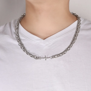 Double-layered silver necklace with star pendant on male model wearing a white t-shirt