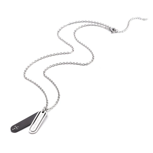 Dettaglio della collana di coppia in acciaio inossidabile con croce e ciondolo di cristallo