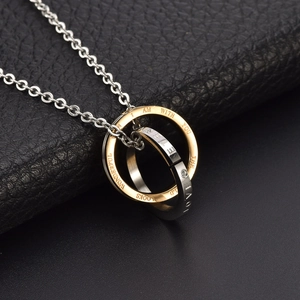 Detail of interlocking gold and silver rings with LOVE FOREVER engraving and small zircon