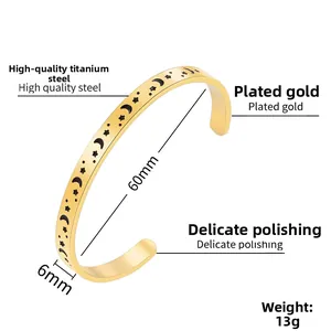 Detailed close-up of gold stainless steel C-shape bangle with celestial moon and star patterns