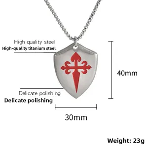Gros plan du pendentif bouclier en acier titane avec croix de Santiago rouge brossé