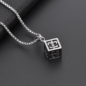 Detail shot of vintage cube pendant with lily engravings on stainless steel chain