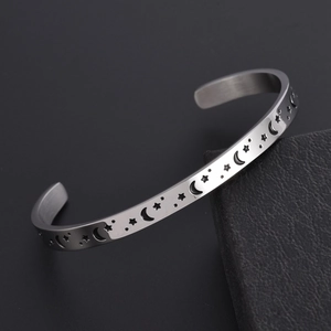 Stainless steel C-shaped open bangle with engraved moon and star patterns