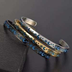 Detailansicht der C-förmigen Titanstahl-Armbänder mit Sonnen-, Mond- und Sternengravur