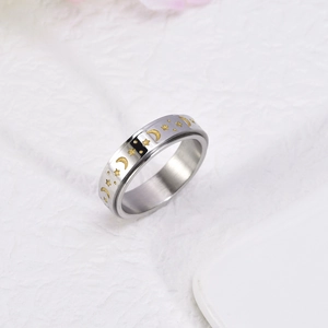 Detailed macro shot of silver spinner ring with golden moon and star relief pattern